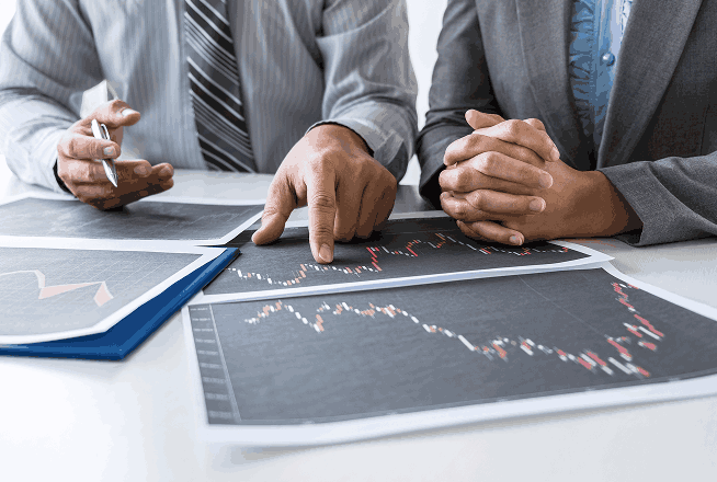 Berater besprechen Finanzdiagramme am Schreibtisch